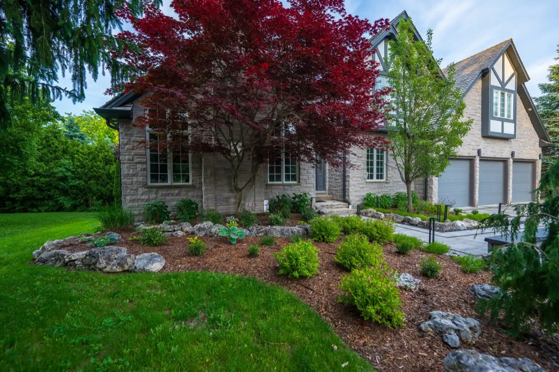Wide view of the estate with Japanese maple and boulder beds