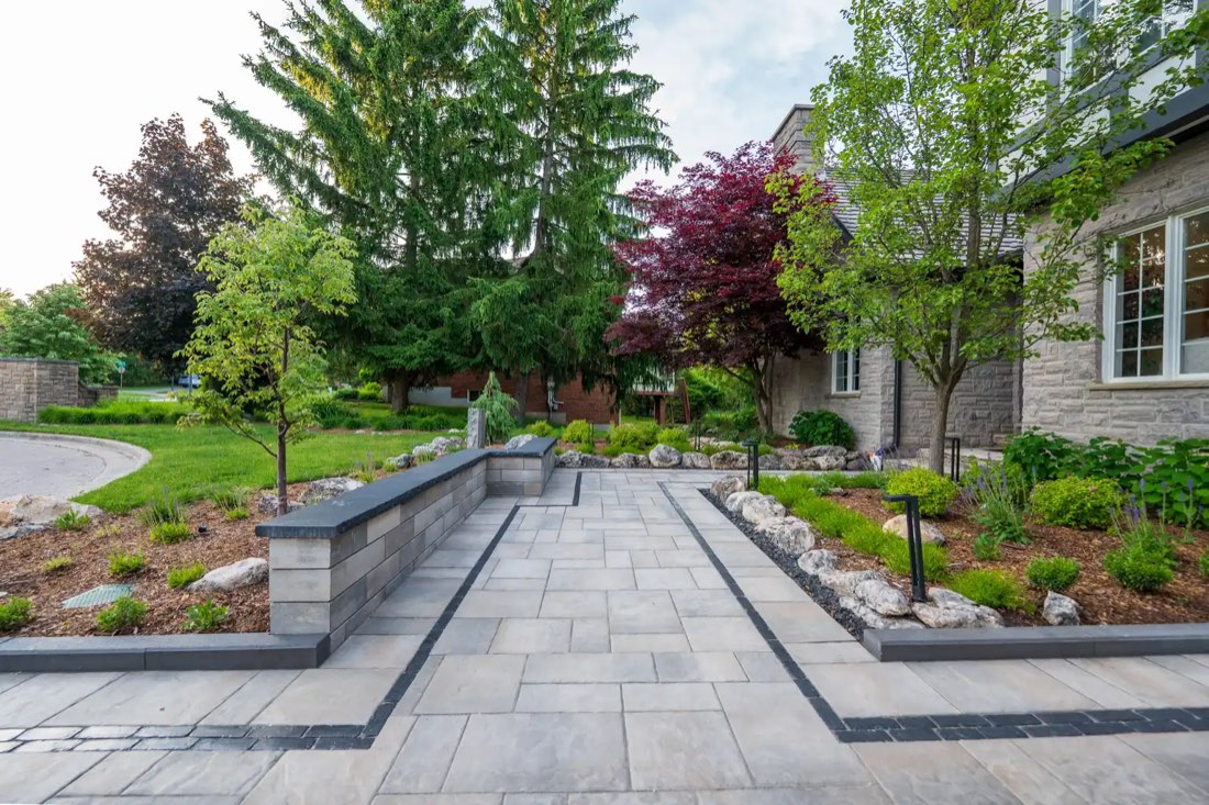 Paver patio with stone seat walls and garden beds