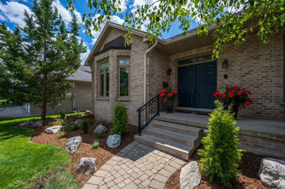 Brick home with fresh foundation plantings and young tree