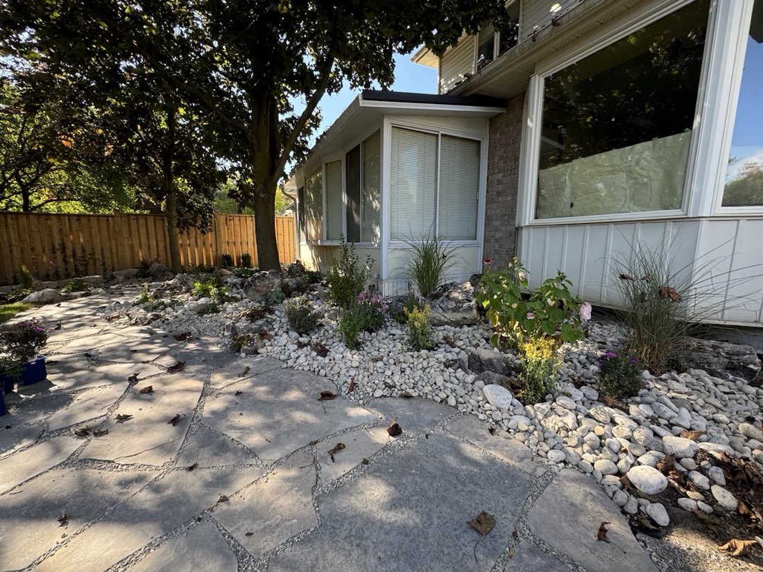 Flagstone and river rock against the house with perennials