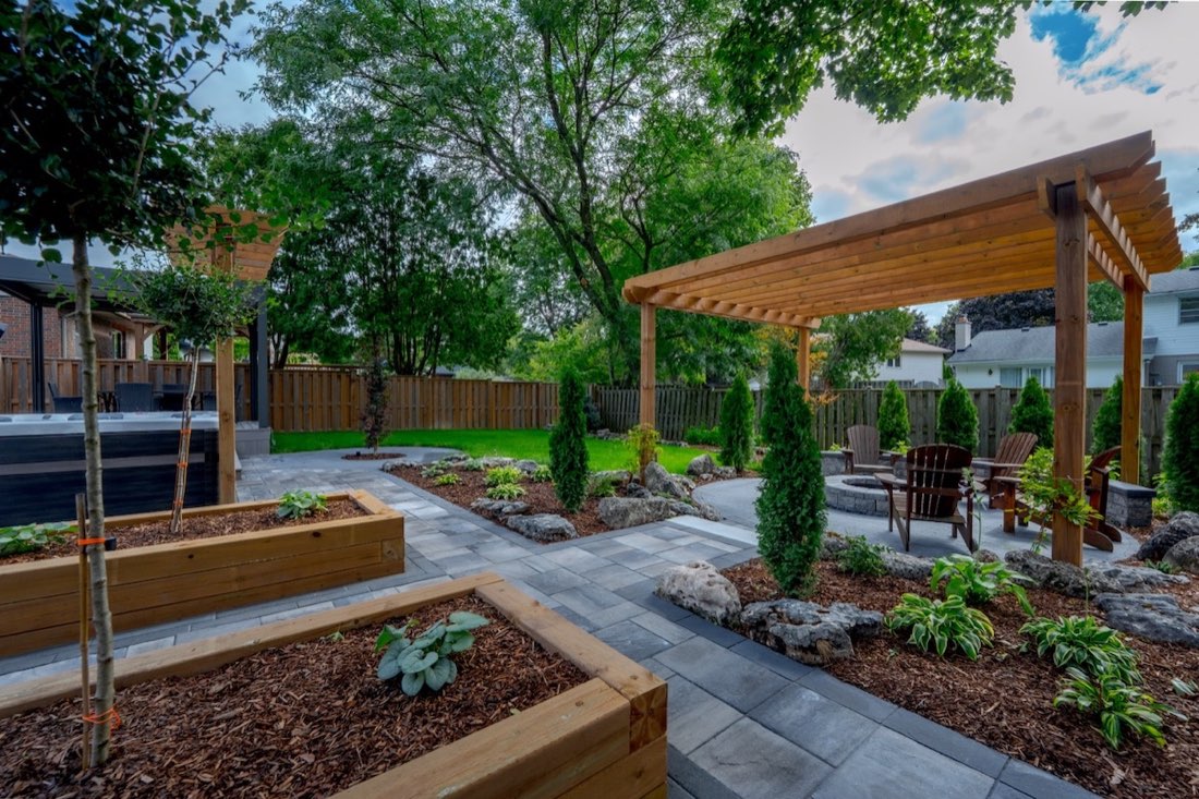 A tidy, designed backyard with pergola and raised garden beds